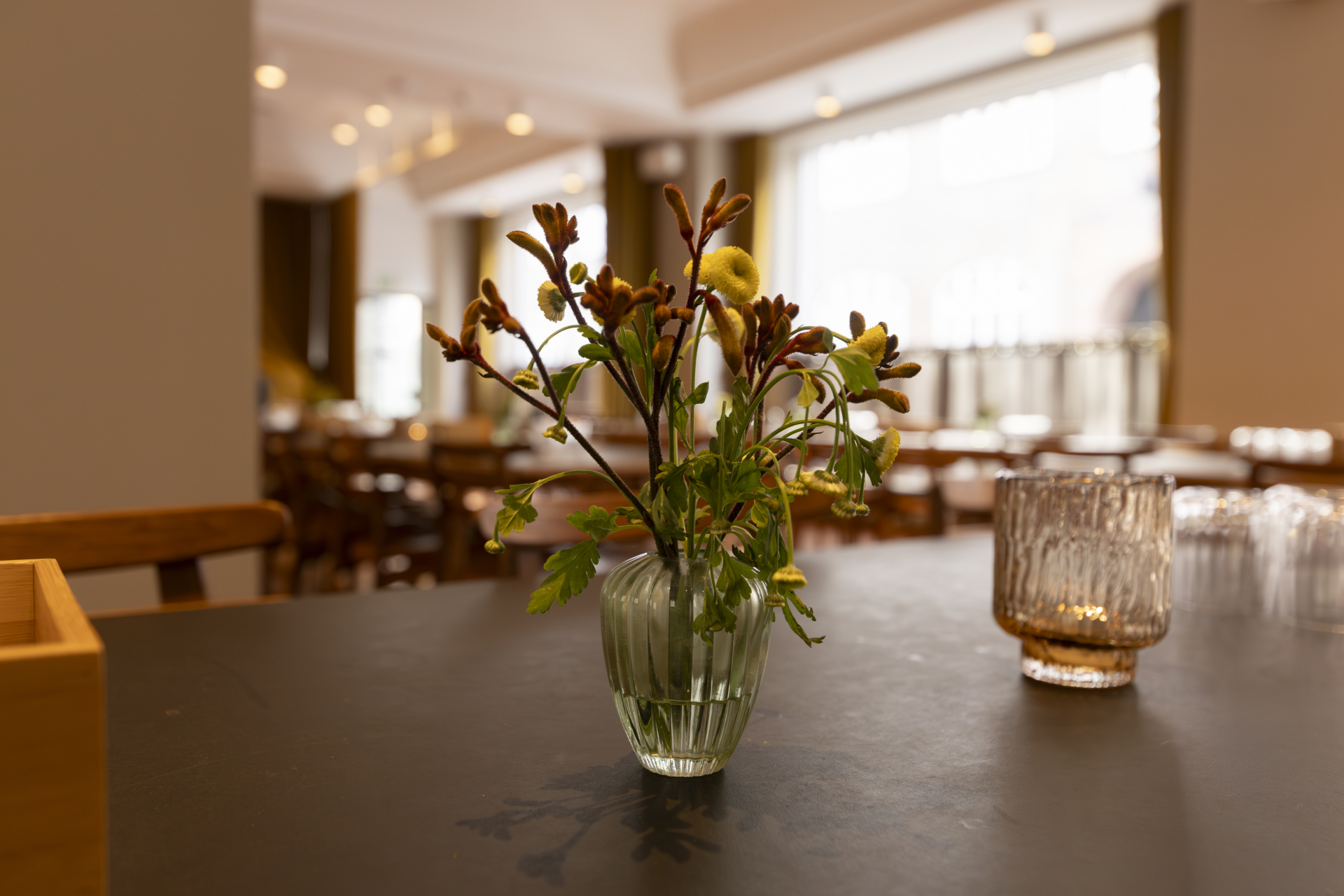 Blomster og lys på bord i kantine